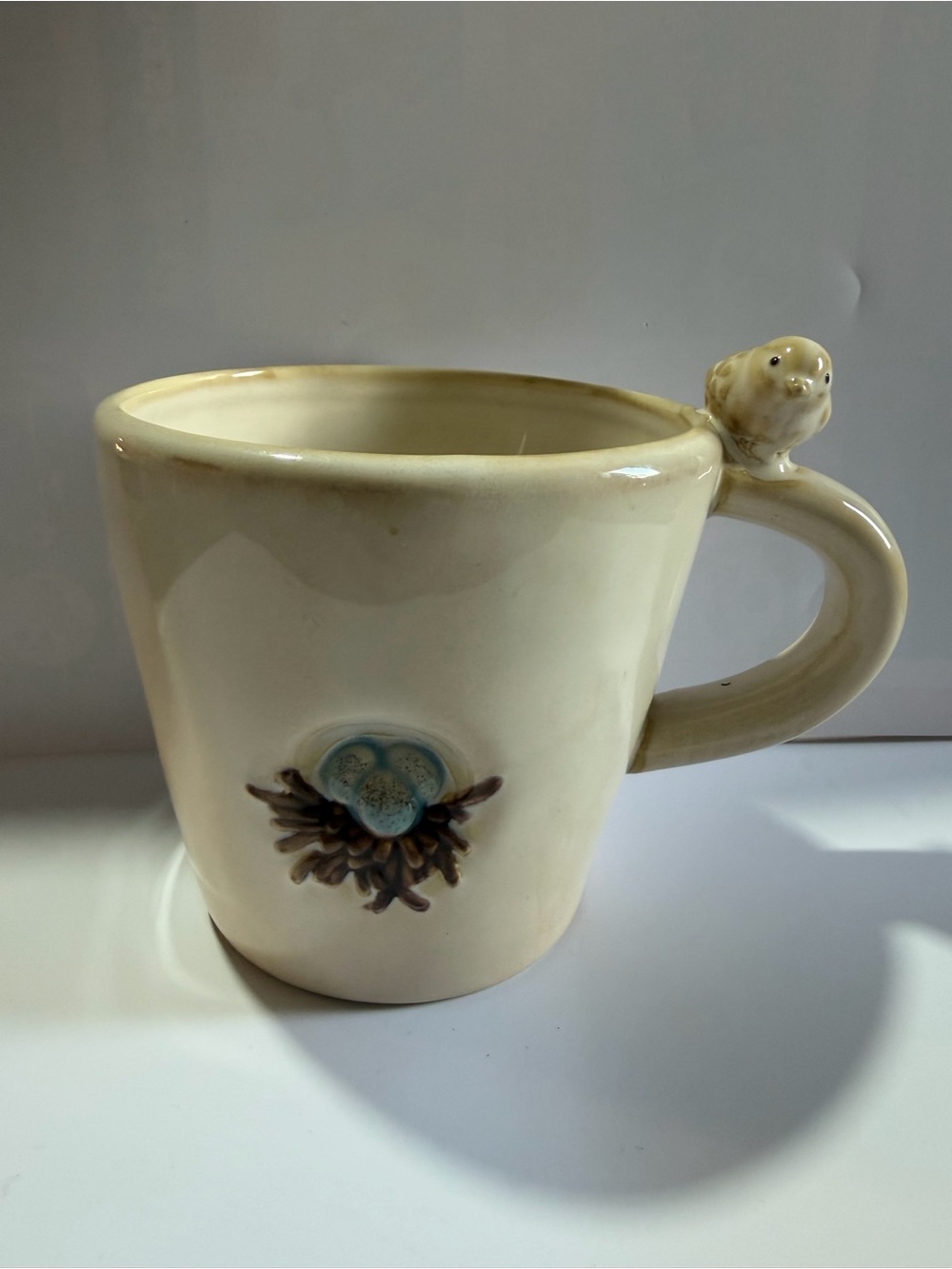 Pottery Barn Cream Ceramic Mug with Blue Floral Medallion and Bird Handle
